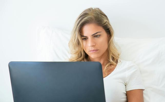 Woman looking at a computer, with a expression of worry on her face