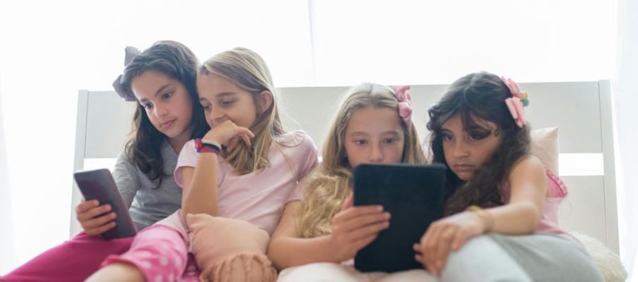 Young girls gazing at their mobile devices