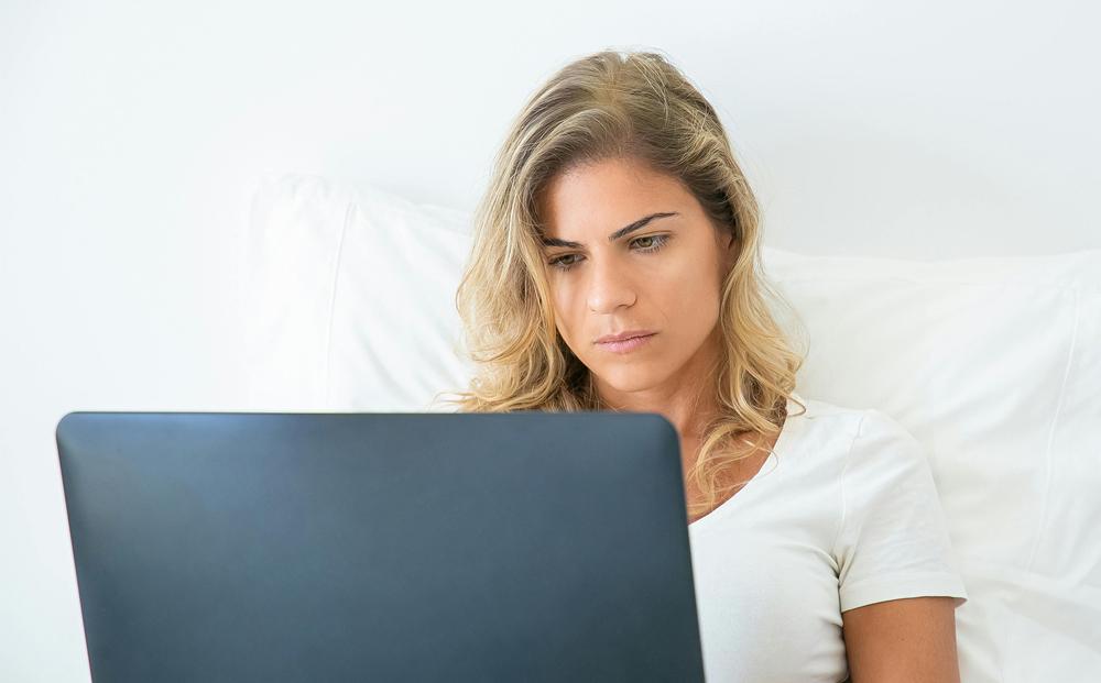 Woman looking at a computer, with a expression of worry on her face